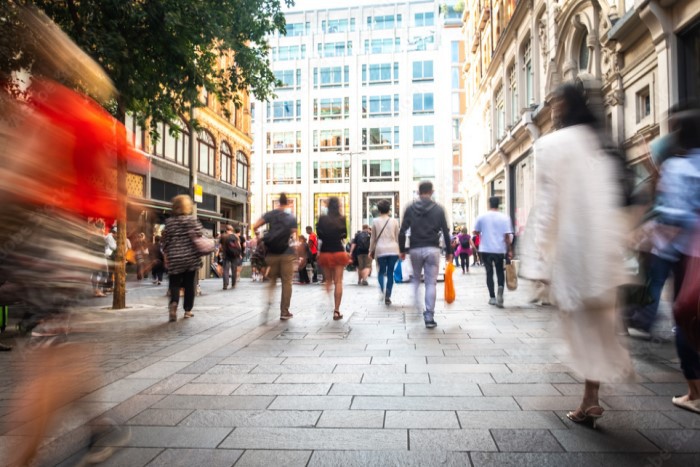Pessoas indo de um lugar a outro em um calçadão, modelo de rua dedicado exclusivamente para pedestres