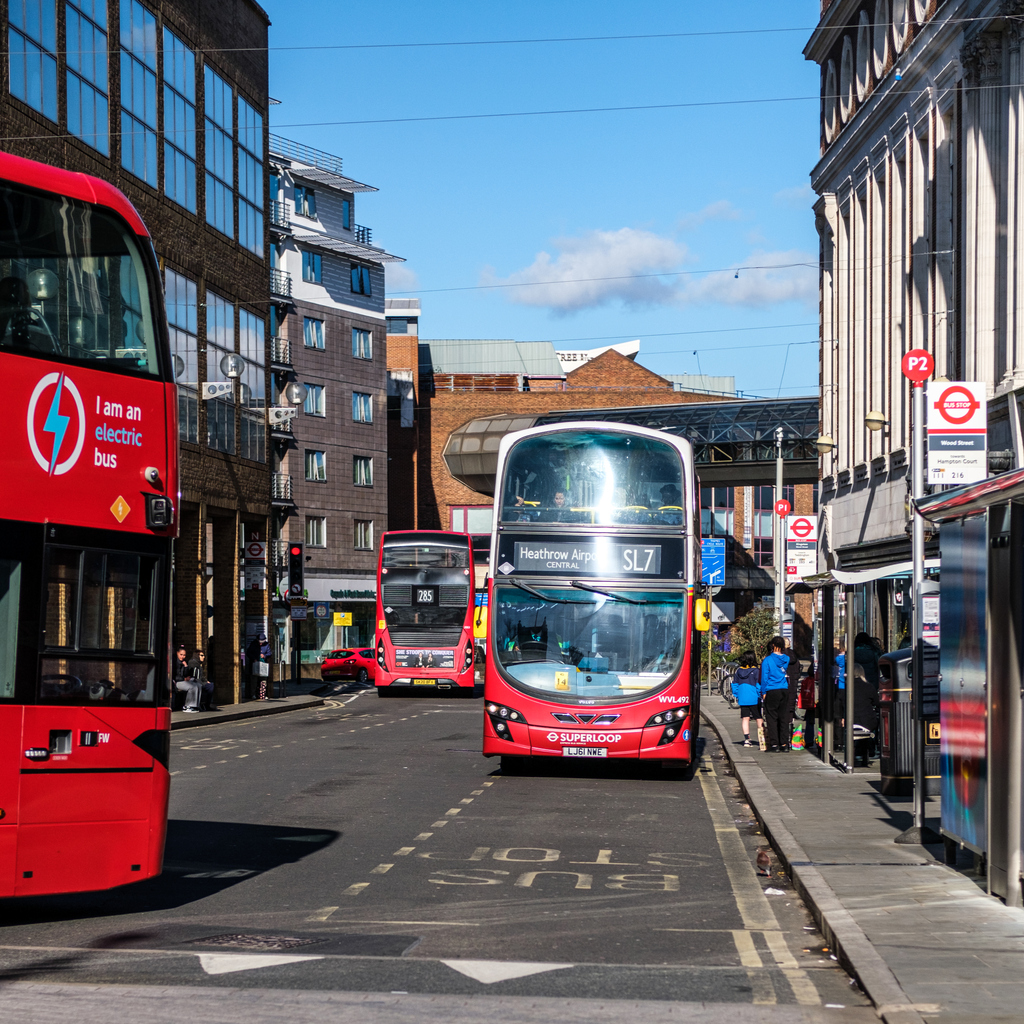 Foto de vários ônibus de duplo piso na rua.