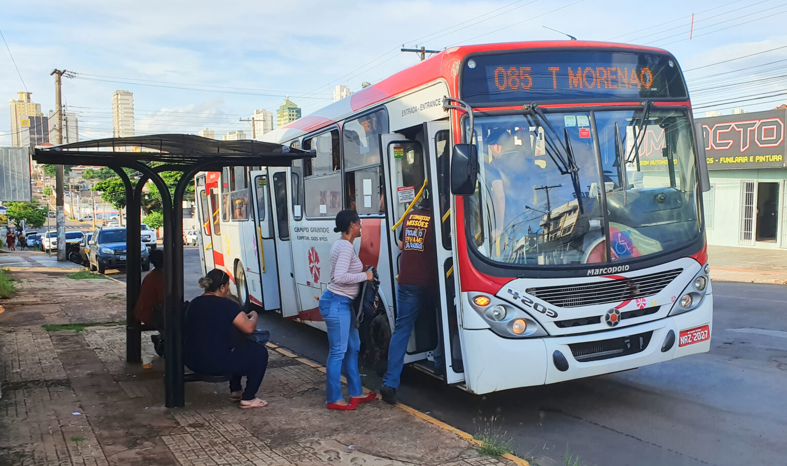 Foto de pessoas entrando em ônibus.