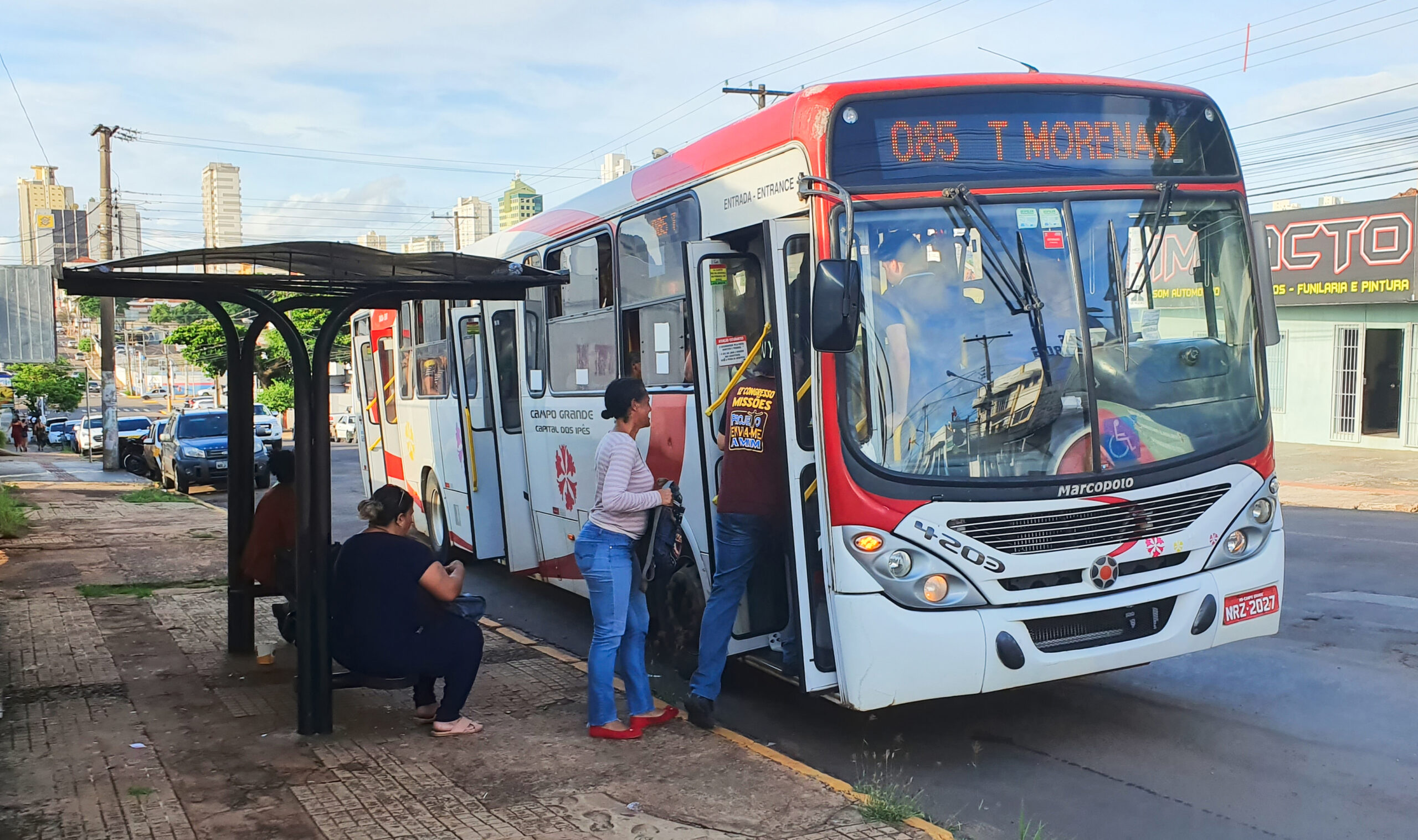 Foto de pessoas entrando em ônibus.