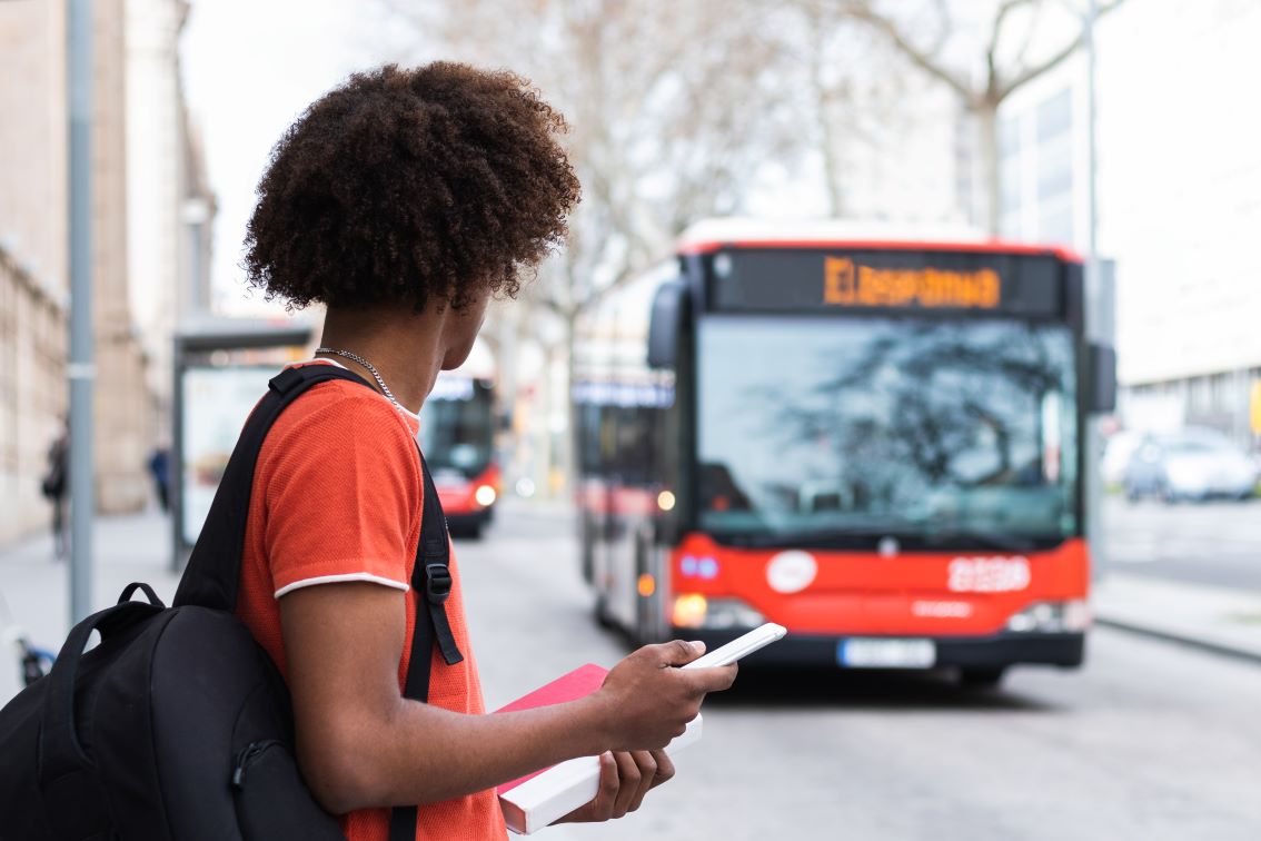 Foto de homem acompanhando a chegada de seu ônibus pelo aplicativo de ônibus.